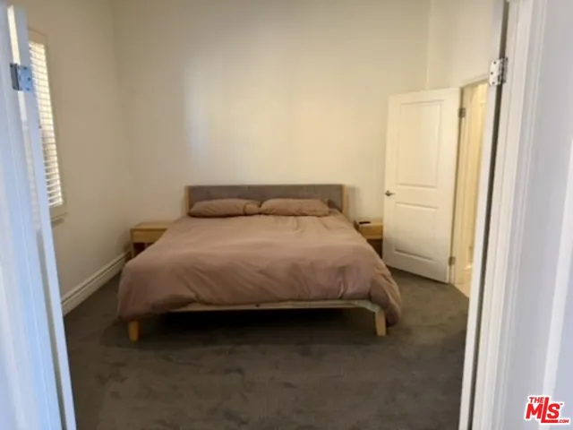 a bed sitting in a bedroom next to a window