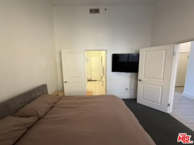 a bedroom with a bed and flat screen tv