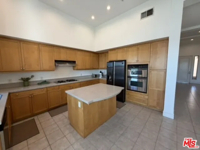 a kitchen with stainless steel appliances granite countertop a refrigerator and a stove top oven