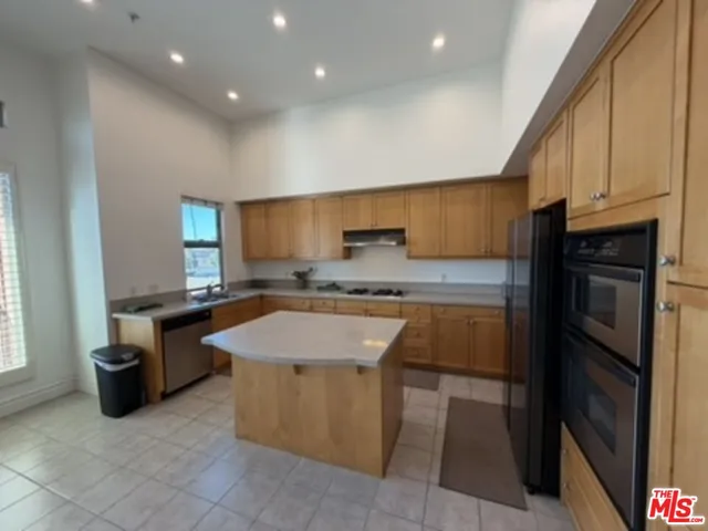 a kitchen with stainless steel appliances granite countertop a sink counter space cabinets and a stove