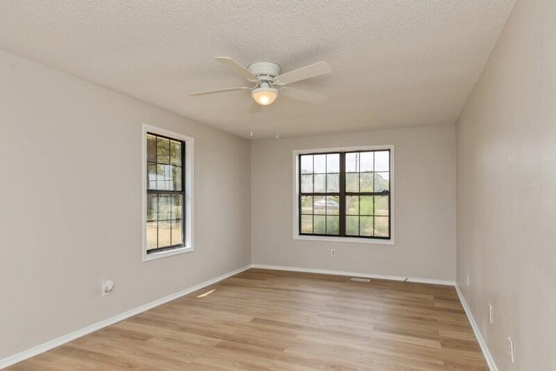 5867 Oak Hill Road Crestview, FL 32536 - Photo 20 of 33 an empty room with wooden floor fan and windows