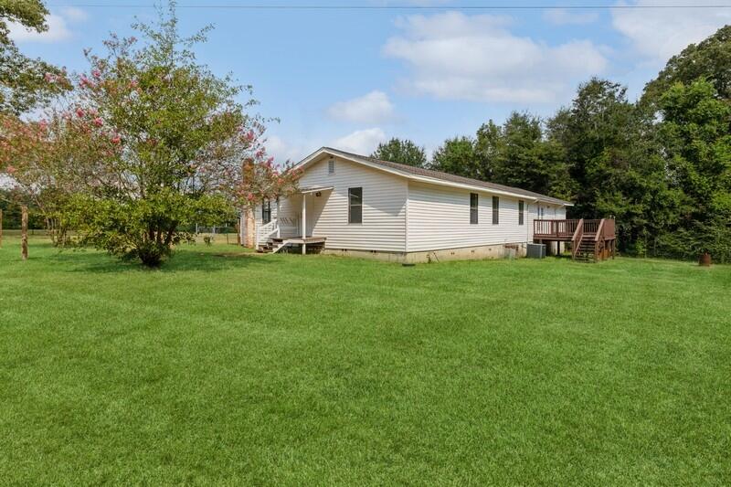5867 Oak Hill Road Crestview, FL 32536 - Photo 5 of 33 a white house that has a big yard with wooden fence
