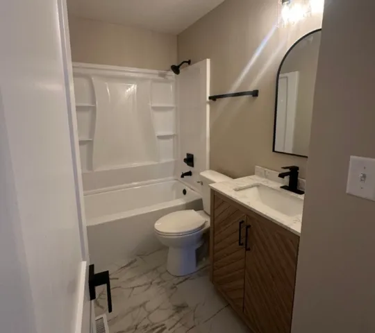 a bathroom with a sink toilet and shower