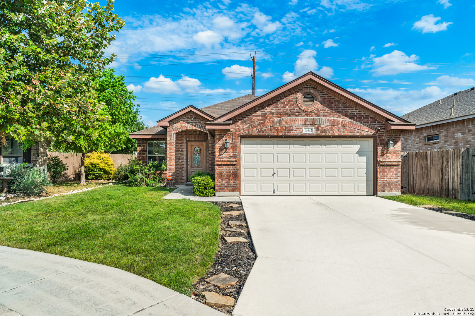 a front view of a house with a garden and plants