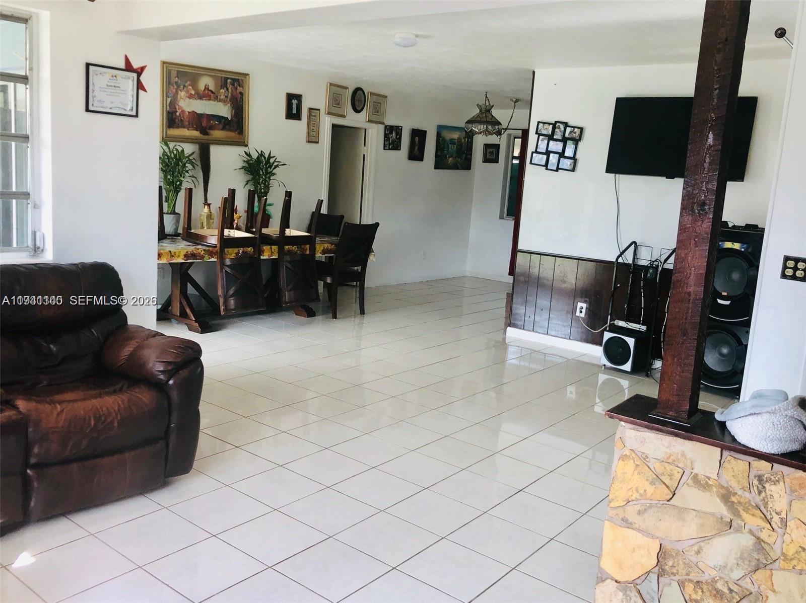 14932 Southwest 297th Terrace Homestead, FL 33033 - Photo 6 of 9 a living room with furniture and a flat screen tv