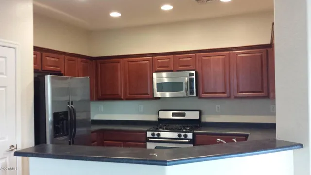 a kitchen with kitchen island granite countertop a stove and a cabinets