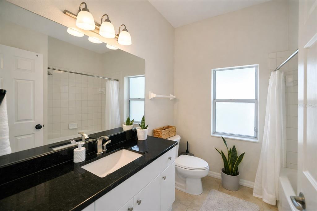 2009 Meadow Rue Court Trinity, FL 34655 - Photo 11 of 21 a bathroom with a granite countertop sink a toilet and a mirror