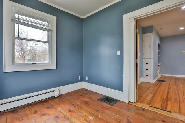 a view of room with window and wooden floor