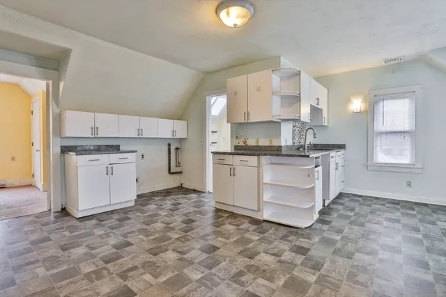 a kitchen with granite countertop white cabinets and white appliances