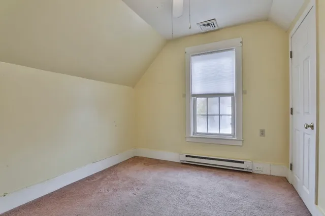 an empty room and a bathroom with a sink