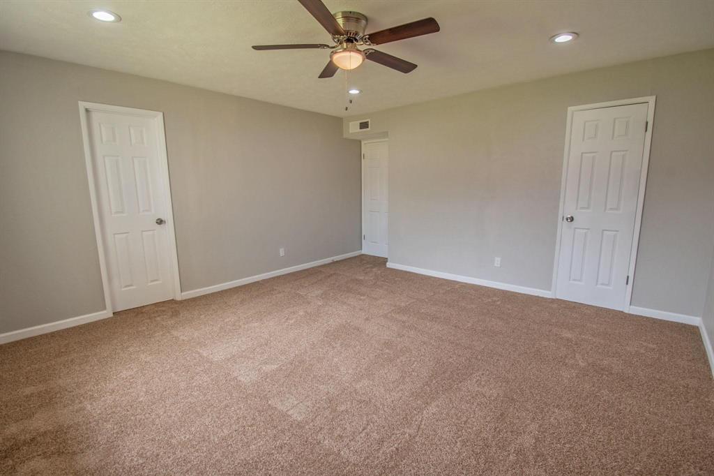 3825 Hackberry Lane Bedford, TX 76021 - Photo 14 of 24 an empty room with a ceiling fan and a window
