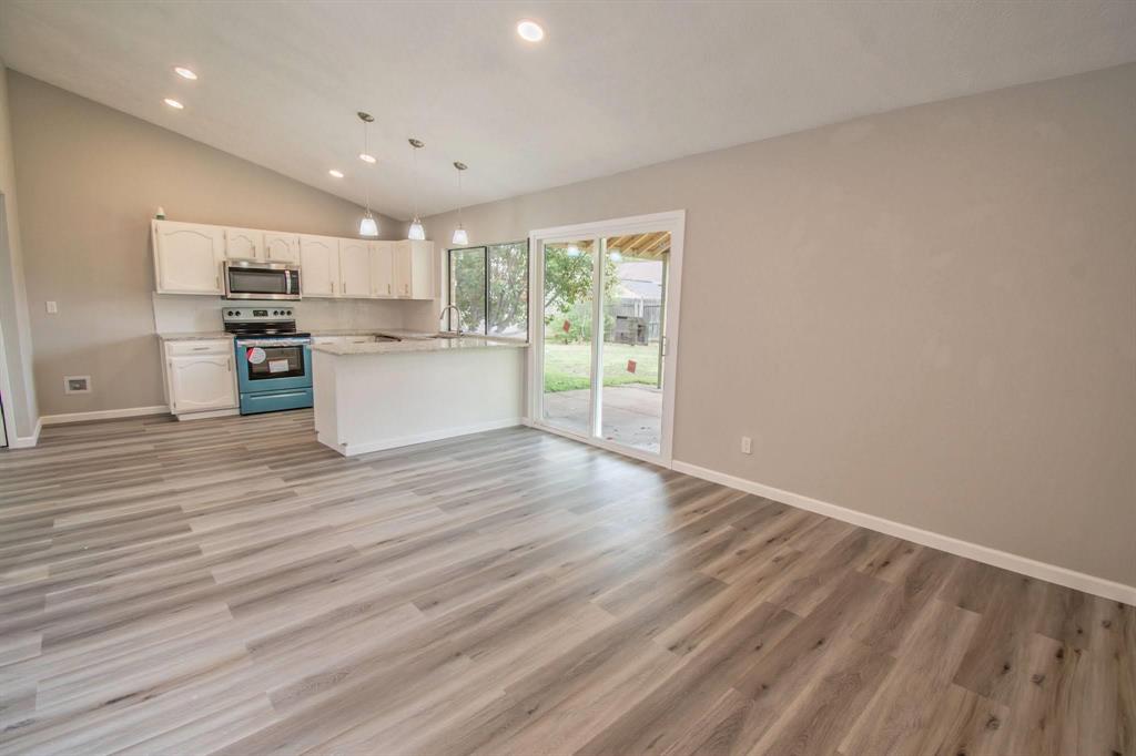 3825 Hackberry Lane Bedford, TX 76021 - Photo 3 of 24 a kitchen with stainless steel appliances wooden floor and view living room