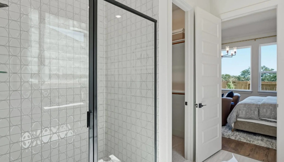 248 Prickly Poppy Way Georgetown, TX 78633 - Photo 9 of 21 Elegant shower featuring distinctive patterned tilework and a sleek black-framed glass enclosure.