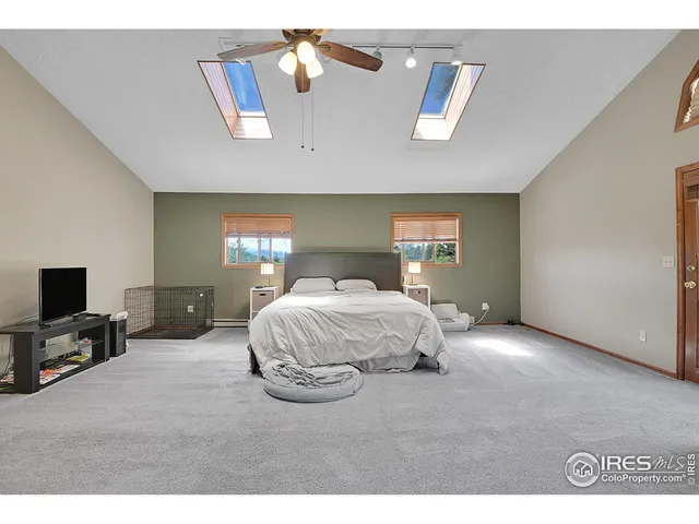 a spacious bedroom with a bed a couch and a flat tv screen