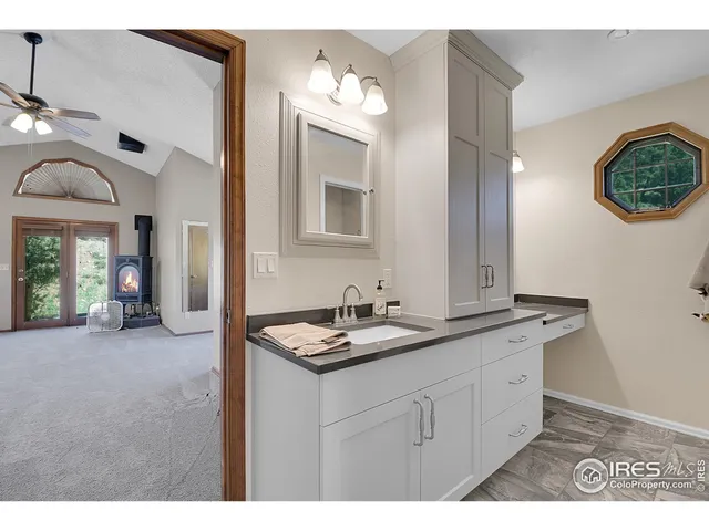 a view of a hallway with a glass door and a bathroom space