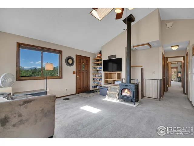 a living room with stainless steel appliances furniture and a flat screen tv