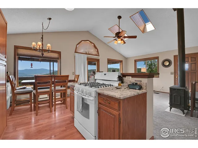 a kitchen with kitchen island a stove a table and chairs