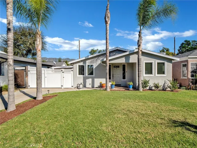 a view of a house with a backyard and a tree