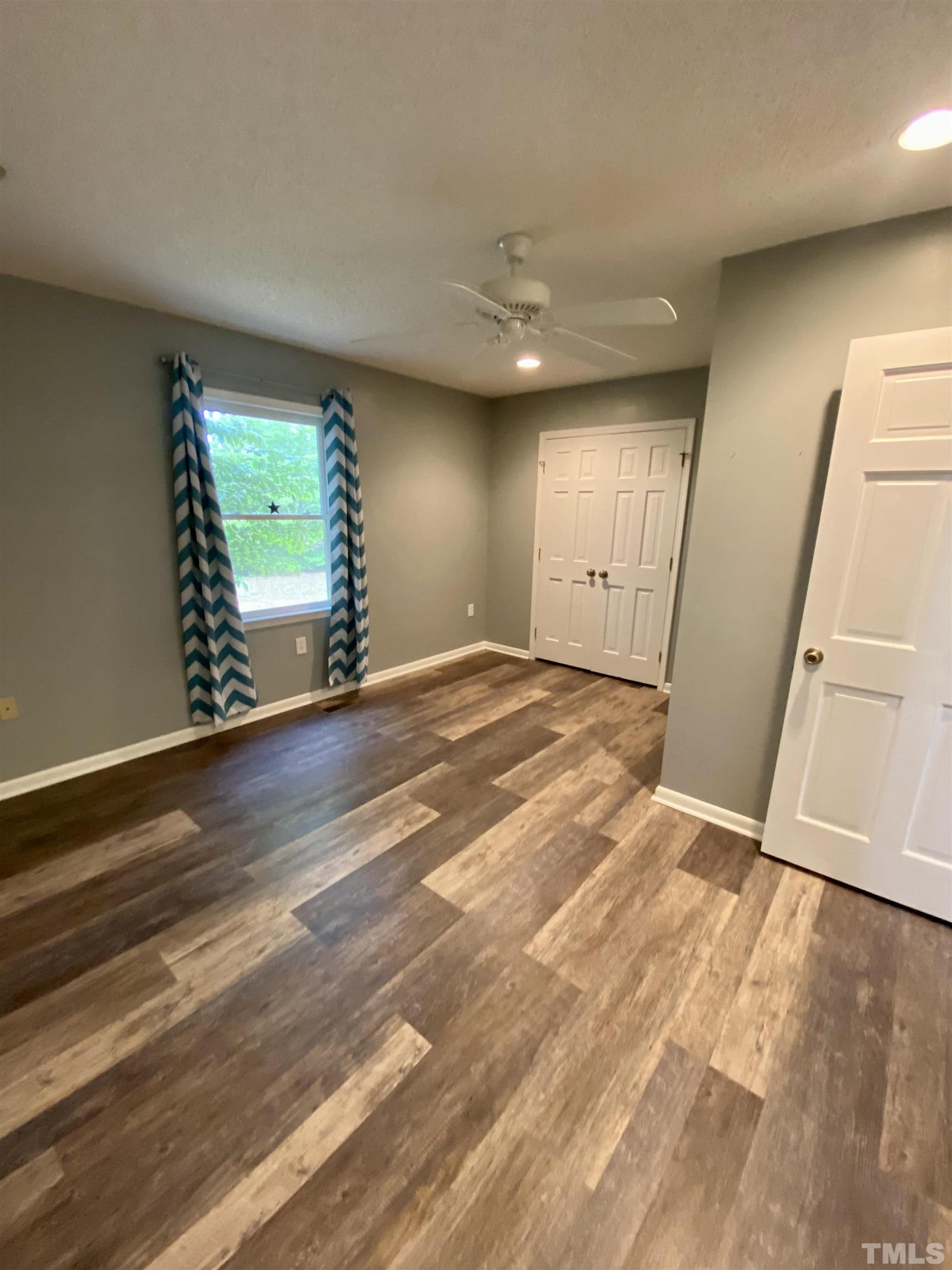1887 Burnside Road Oxford, NC 27565 - Photo 18 of 42 an empty room with wooden floor and a window