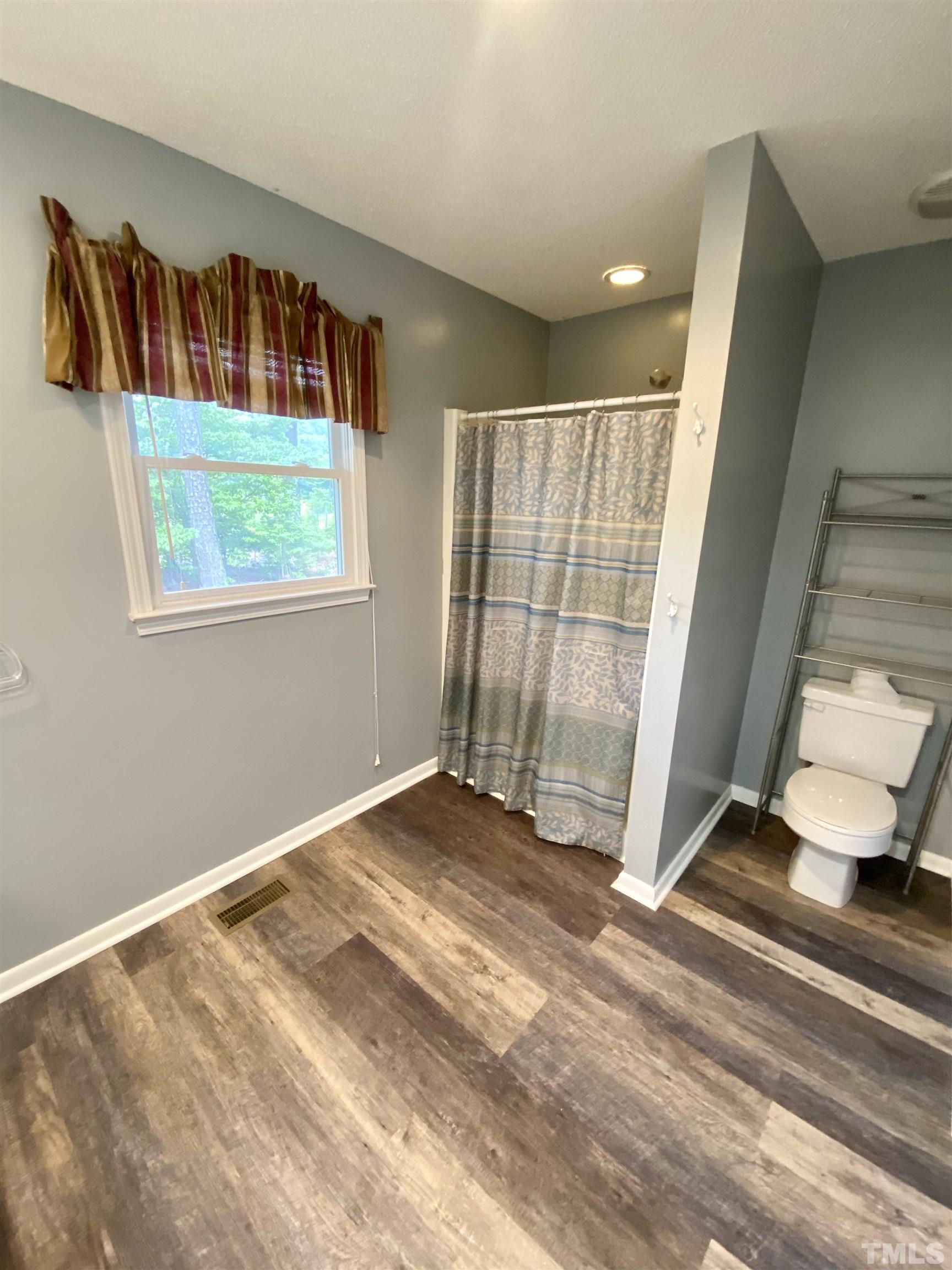 1887 Burnside Road Oxford, NC 27565 - Photo 21 of 42 a view of an empty room with wooden floor and a window