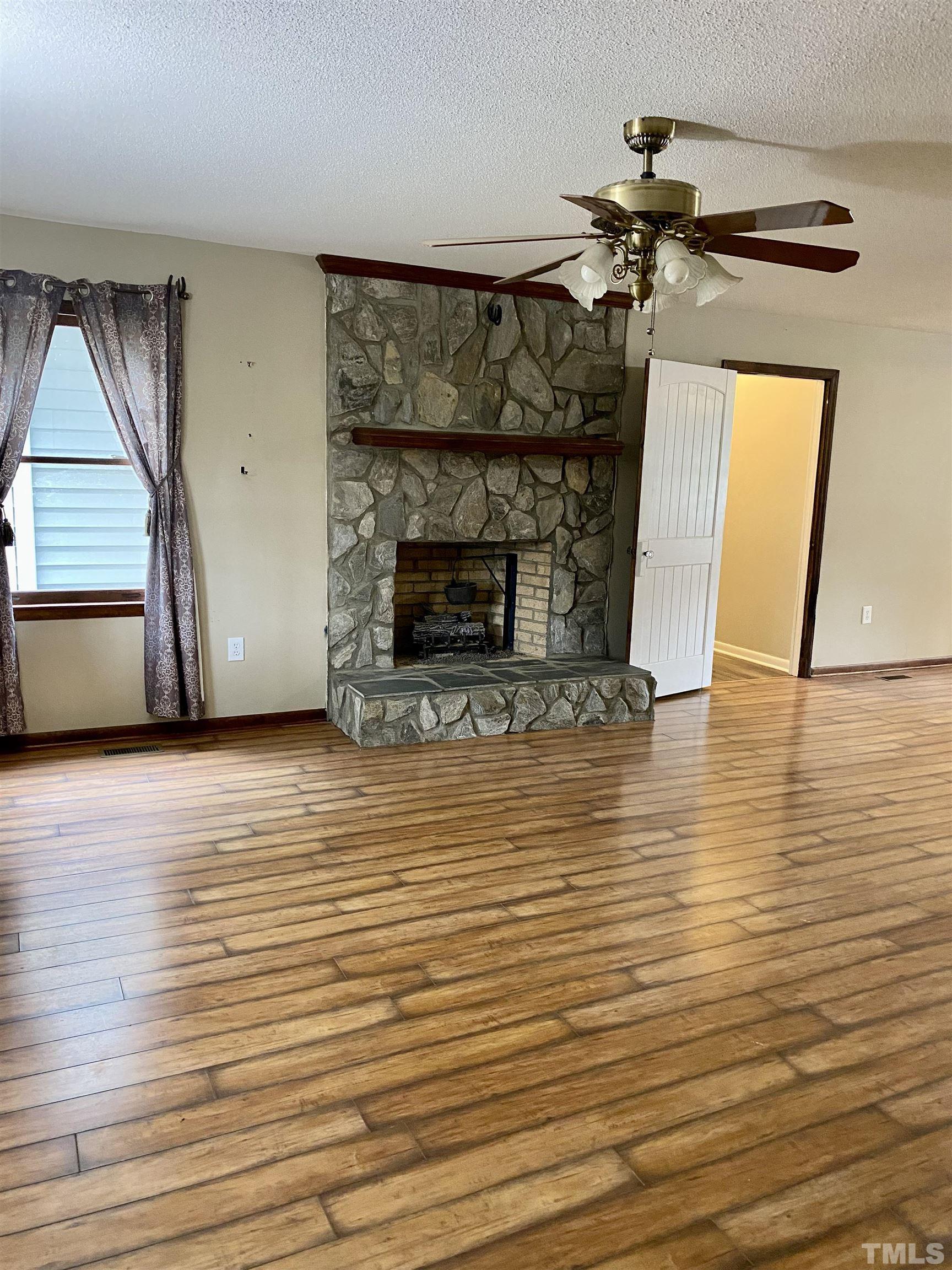 1887 Burnside Road Oxford, NC 27565 - Photo 5 of 42 a view of a livingroom with wooden floor and a fireplace
