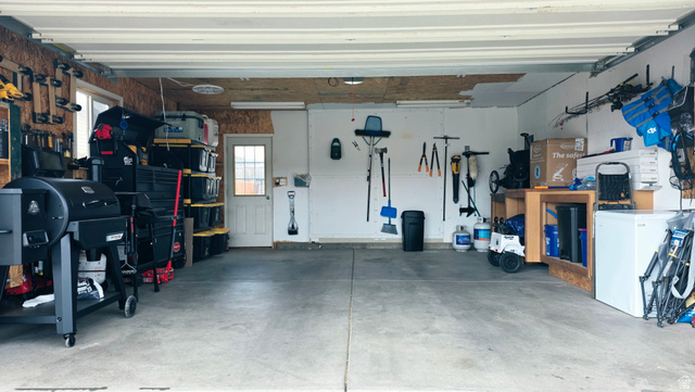 401 West 2000th Street South Vernal, UT 84078 - Photo 25 of 26 Spacious garage featuring a concrete floor, built-in shelving, and a side access door with a window
