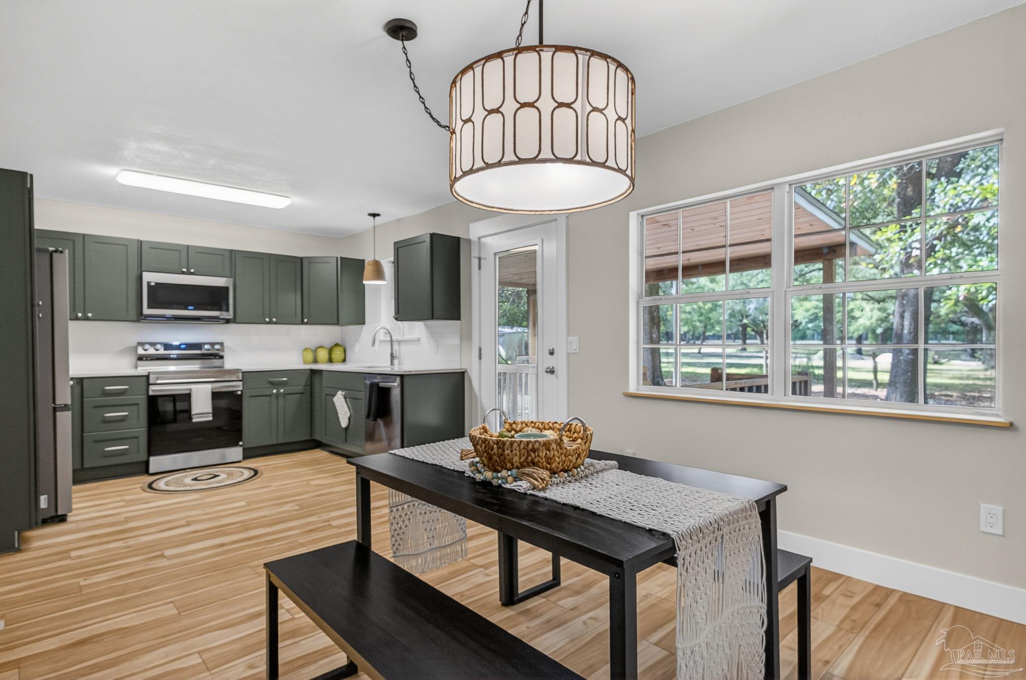 4771 Carl Booker Road Milton, FL 32583 - Photo 15 of 65 a kitchen with stainless steel appliances a dining table chairs stove refrigerator and cabinets