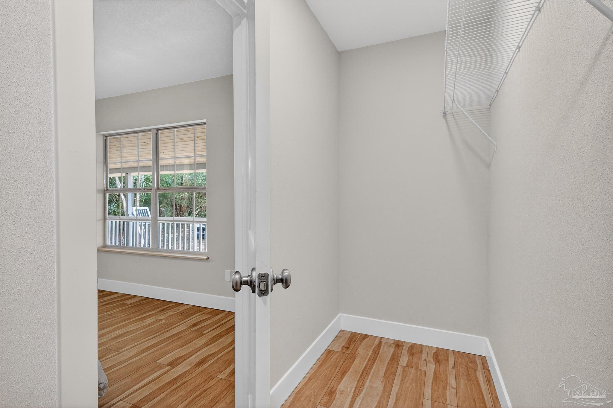4771 Carl Booker Road Milton, FL 32583 - Photo 43 of 65 a view of an empty room with wooden floor and a window
