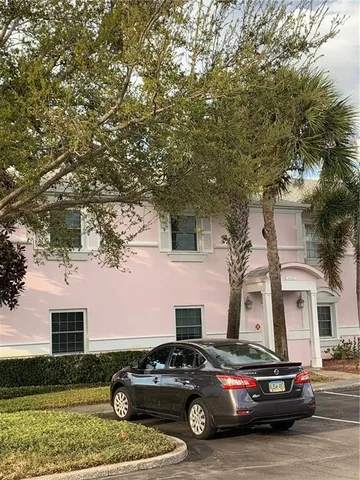 a car parked in front of a white house