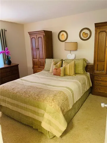 a bedroom with a bed and a lamp on dresser
