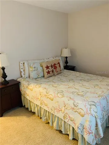 a large bed sitting in a bedroom next to a lamp