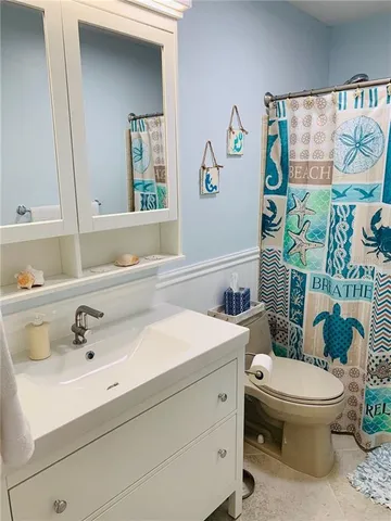 a bathroom with a sink mirror and toilet
