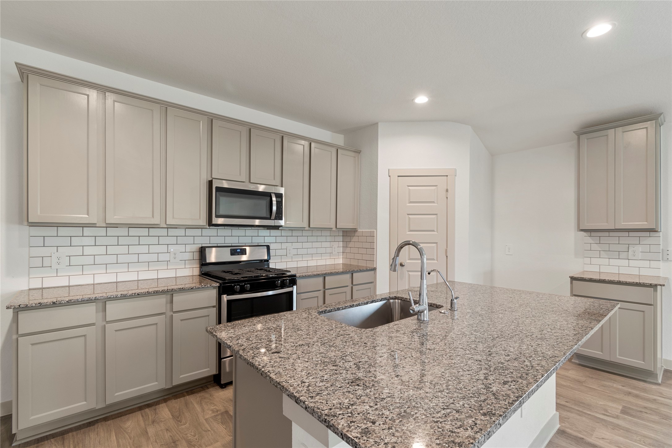 1203 Truckee River Drive Rosharon, TX 77583 - Photo 4 of 12 a kitchen with kitchen island granite countertop a sink a stove counter space and cabinets