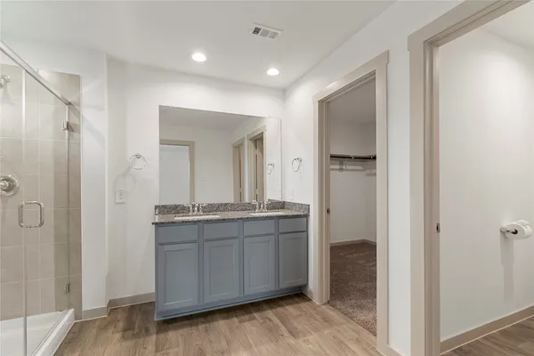 a bathroom with a granite countertop sink mirror and shower