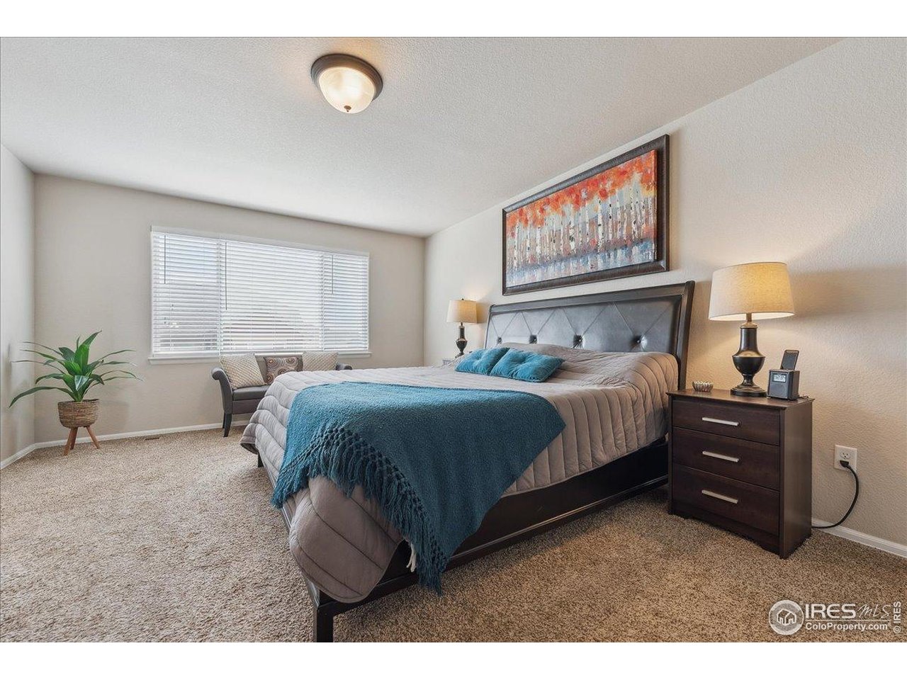 623 Gore Range Drive Severance, CO 80550 - Photo 13 of 36 a bedroom with a bed and a painting on the wall