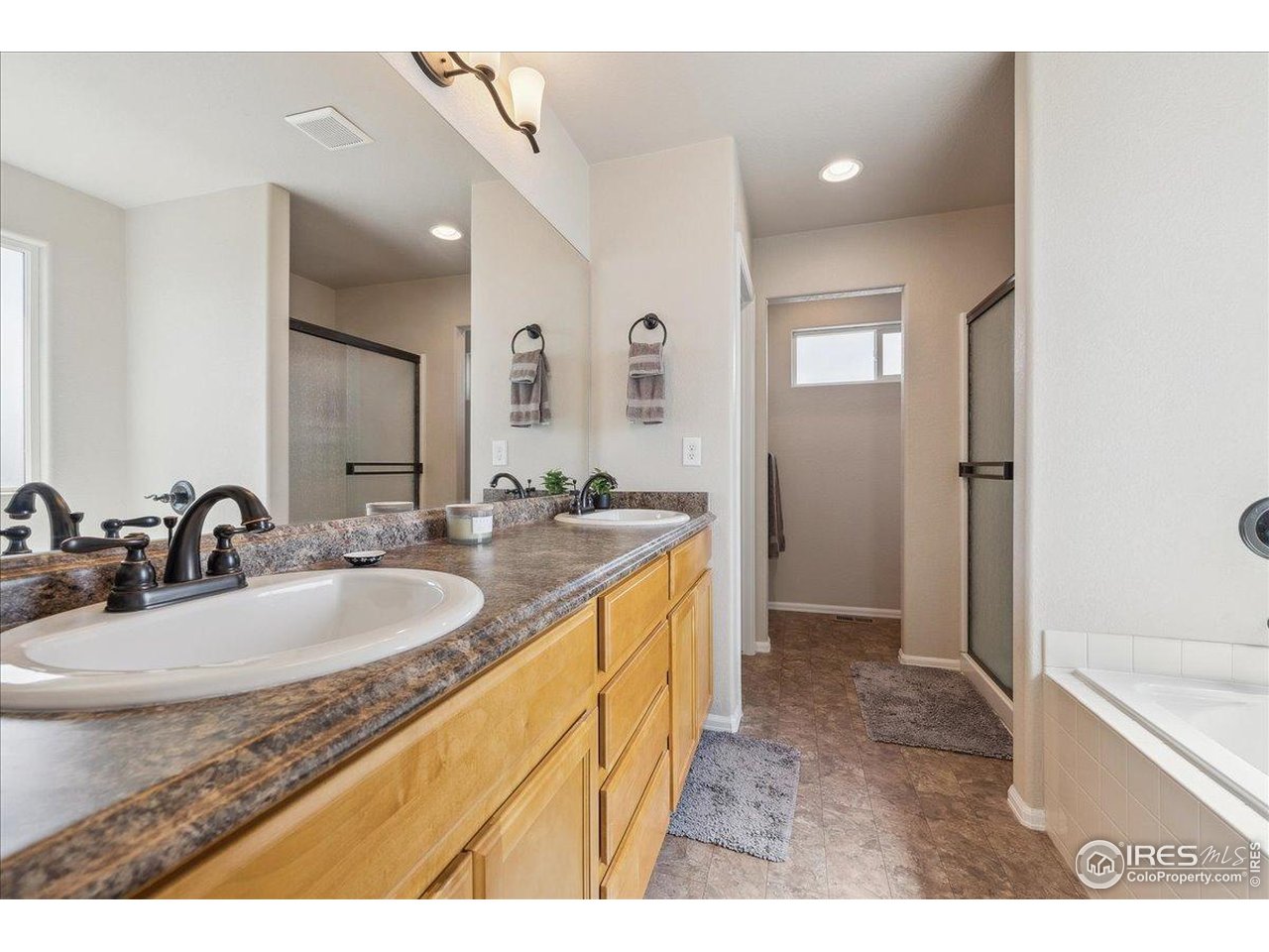623 Gore Range Drive Severance, CO 80550 - Photo 14 of 36 a bathroom with a granite countertop sink mirror and a bathtub
