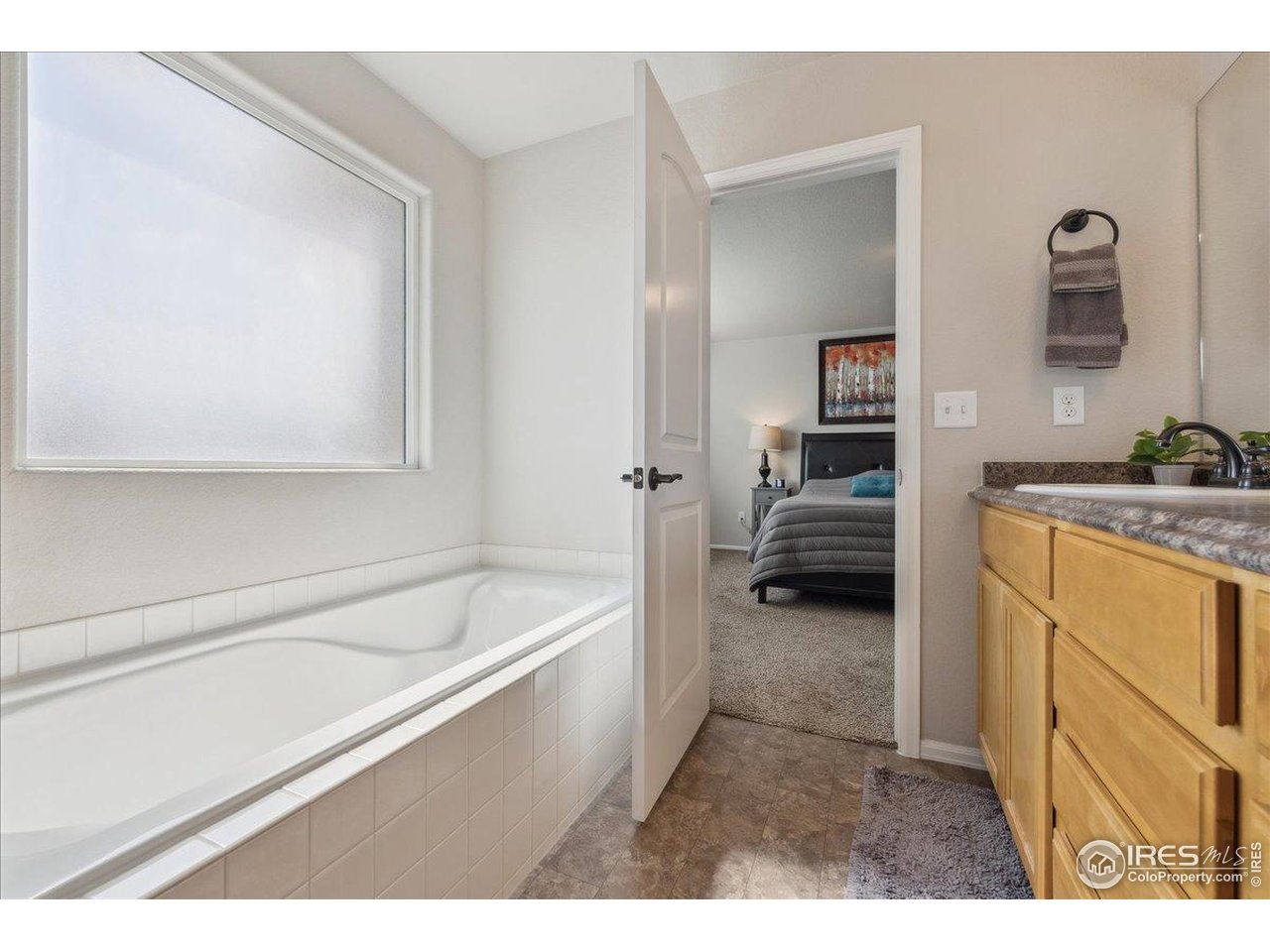 623 Gore Range Drive Severance, CO 80550 - Photo 15 of 36 a en suite bathroom with a tub sink and mirror