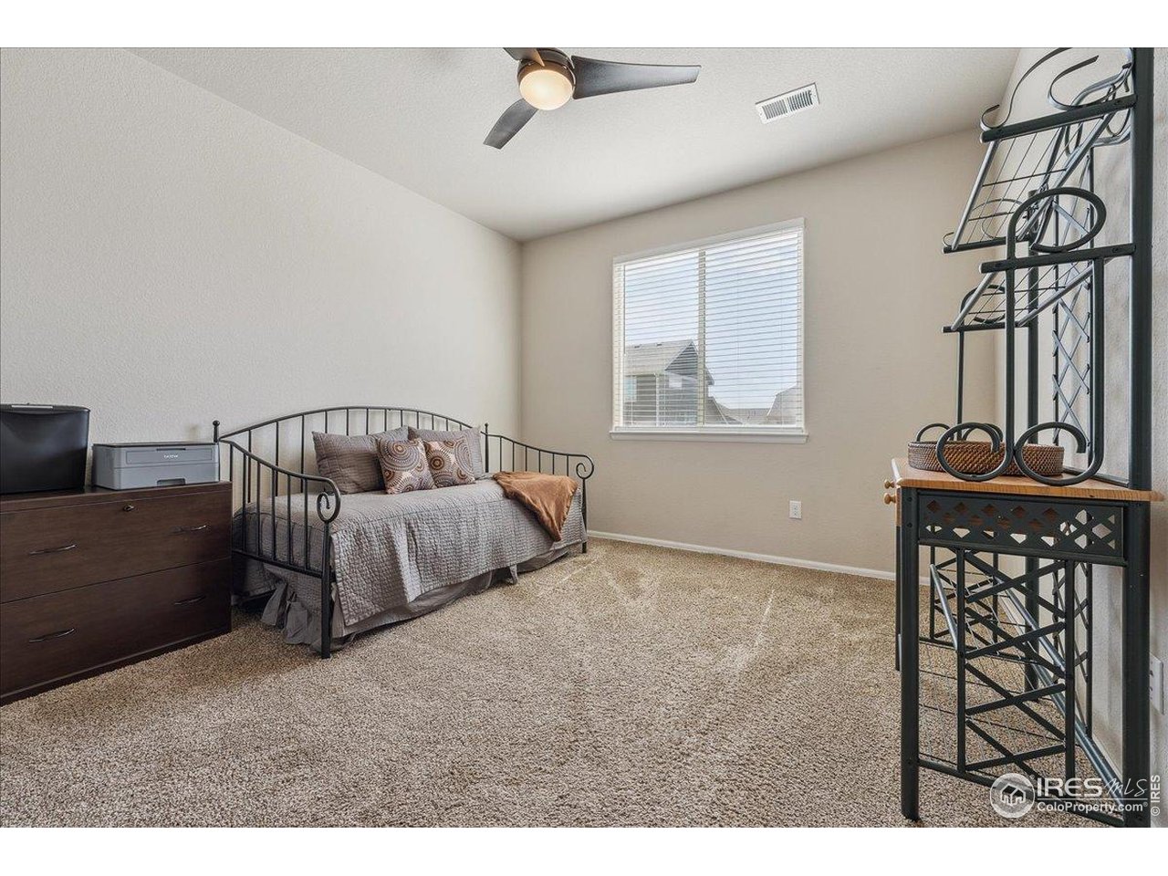 623 Gore Range Drive Severance, CO 80550 - Photo 21 of 36 a bedroom with a bed a chandelier and dresser