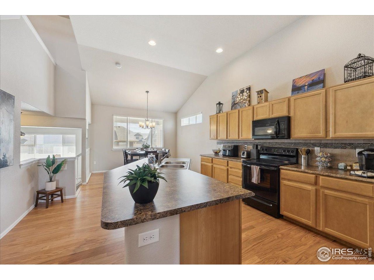 623 Gore Range Drive Severance, CO 80550 - Photo 3 of 36 a kitchen with stainless steel appliances kitchen island granite countertop a sink dishwasher stove and cabinets with wooden floor