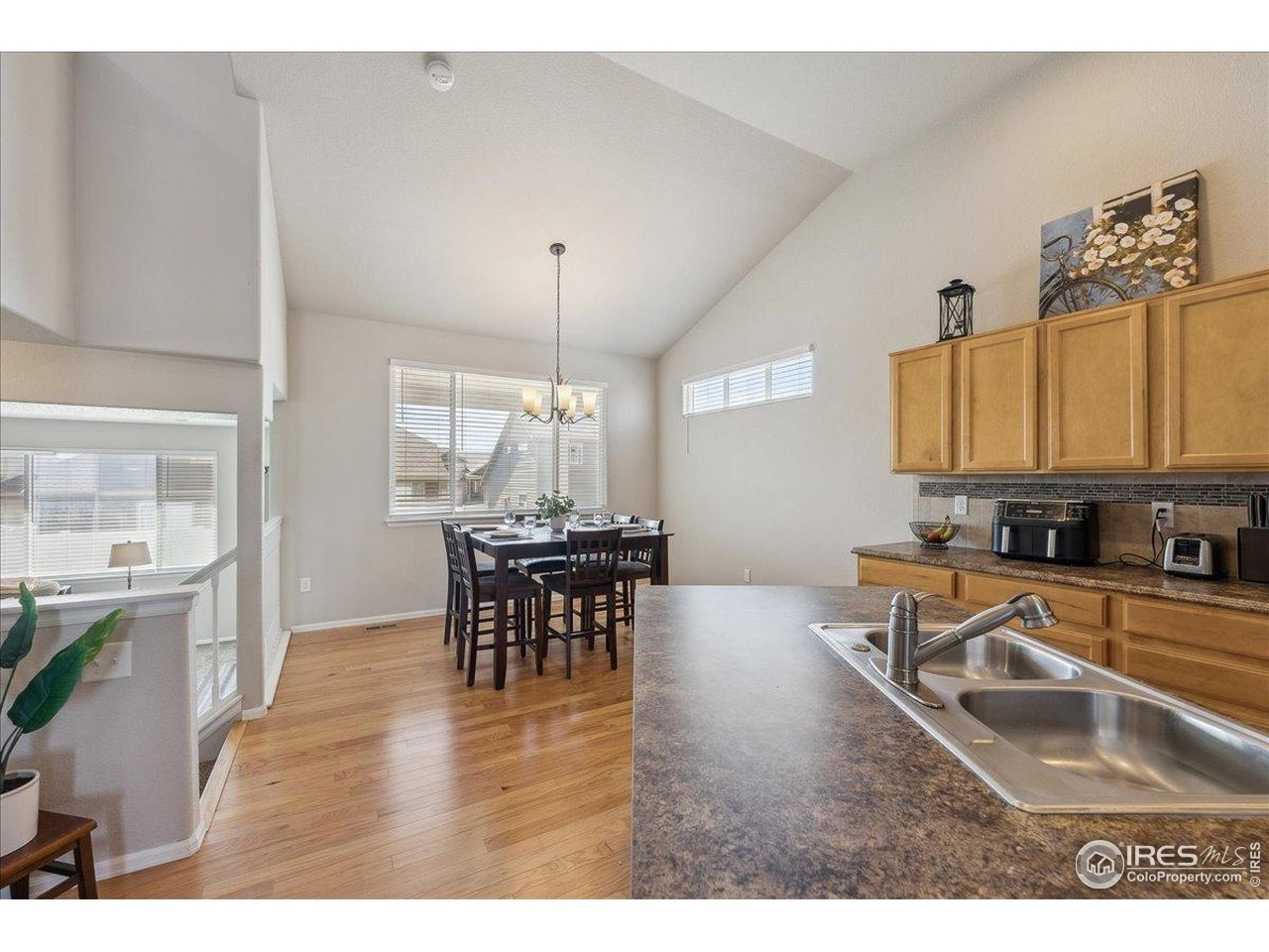 623 Gore Range Drive Severance, CO 80550 - Photo 5 of 36 a kitchen with a dining table chairs and white cabinets