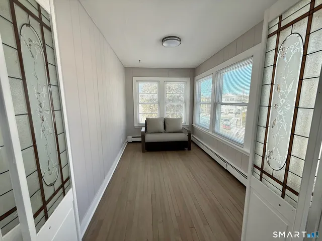 a view of a room with wooden floor and furniture
