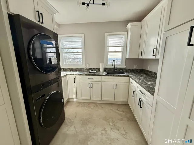 a kitchen with stainless steel appliances granite countertop white cabinets and window