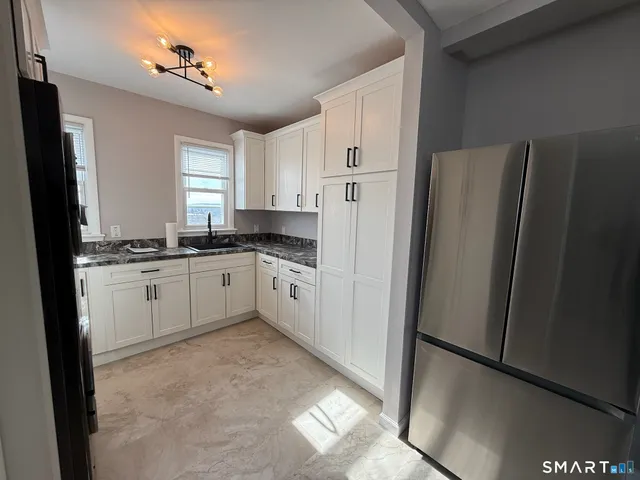 a white refrigerator freezer sitting inside of a kitchen