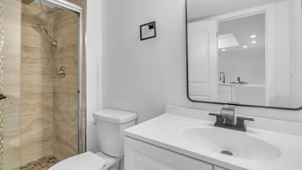 a bathroom with a sink a toilet and shower