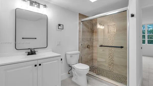 a bathroom with a shower a toilet and a sink