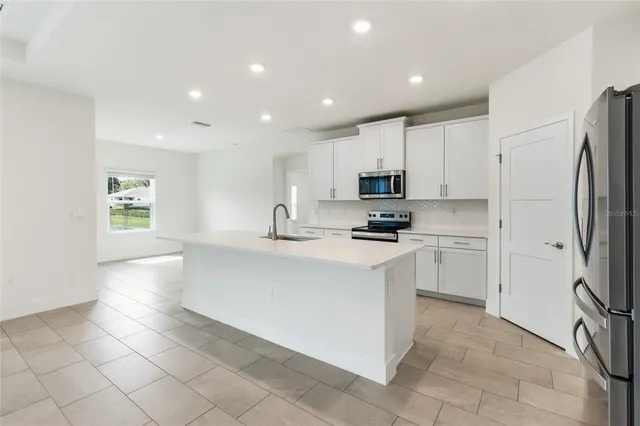 a kitchen with stainless steel appliances a refrigerator sink and microwave