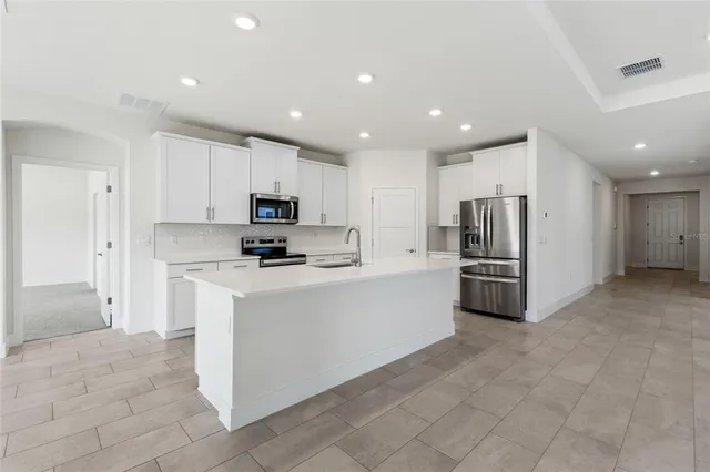 a kitchen with stainless steel appliances a refrigerator sink and microwave