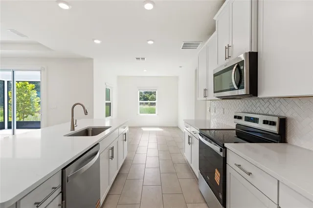 a kitchen with stainless steel appliances granite countertop a sink and a microwave