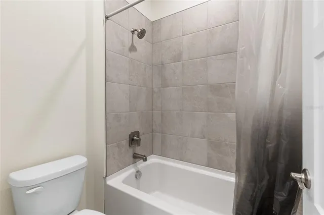 a white bath tub sitting next to a white toilet and a shower