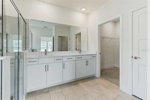 a spacious bathroom with a shower sink and mirror